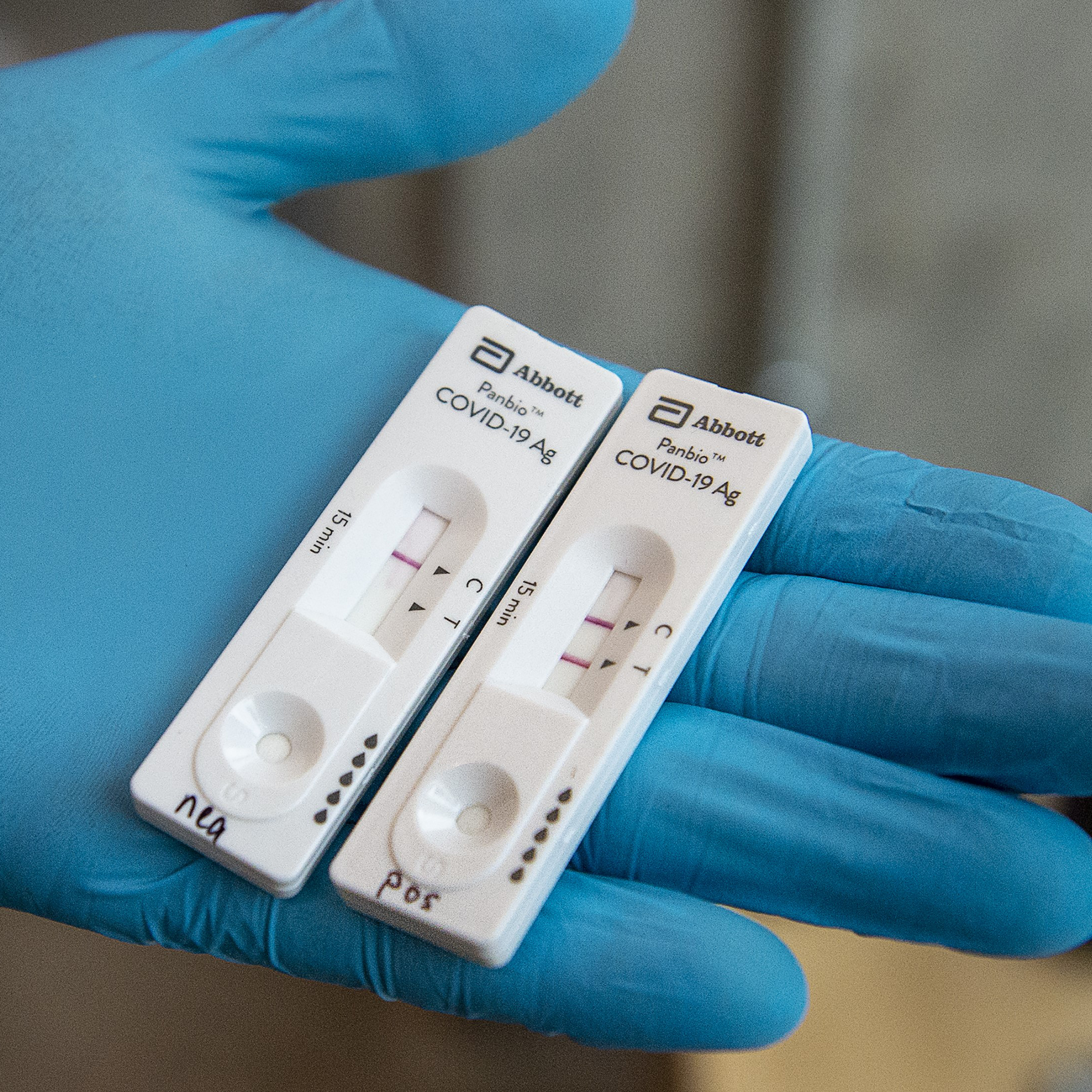 Abboott COVID-19 rapid antigen test. One test shows a negative result the other test shows a positive result.